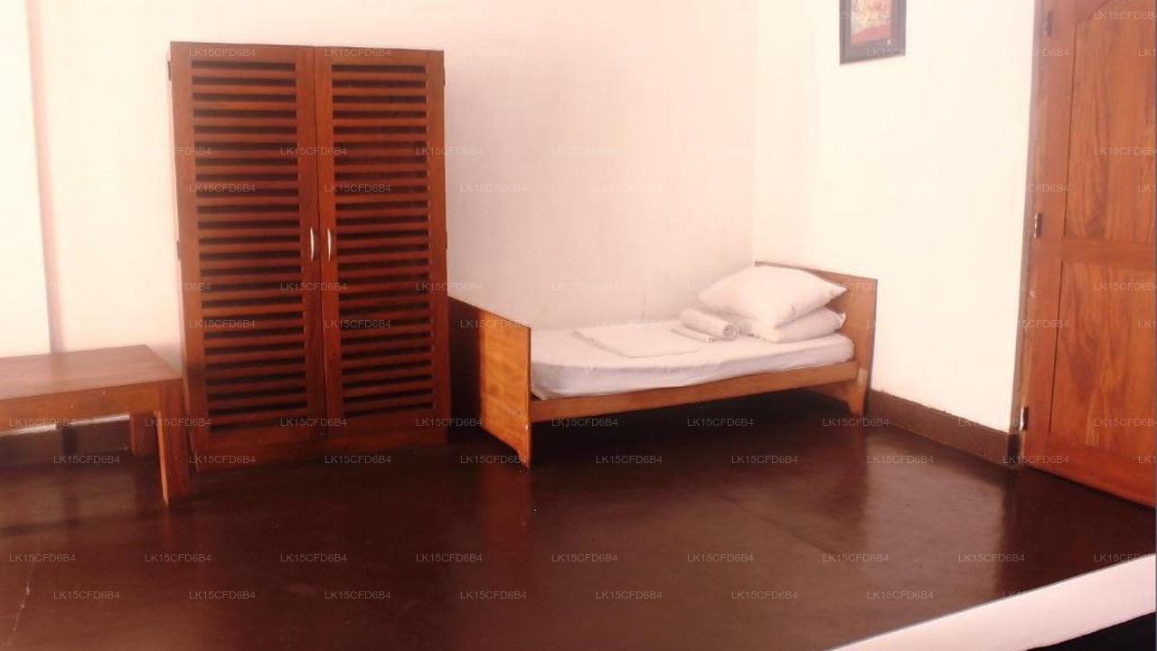 Small bedroom with wooden bed, wardrobe, and bench.
