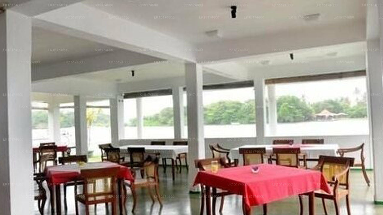 Large dining hall with tables and chairs, large windows, and a view of trees outside.