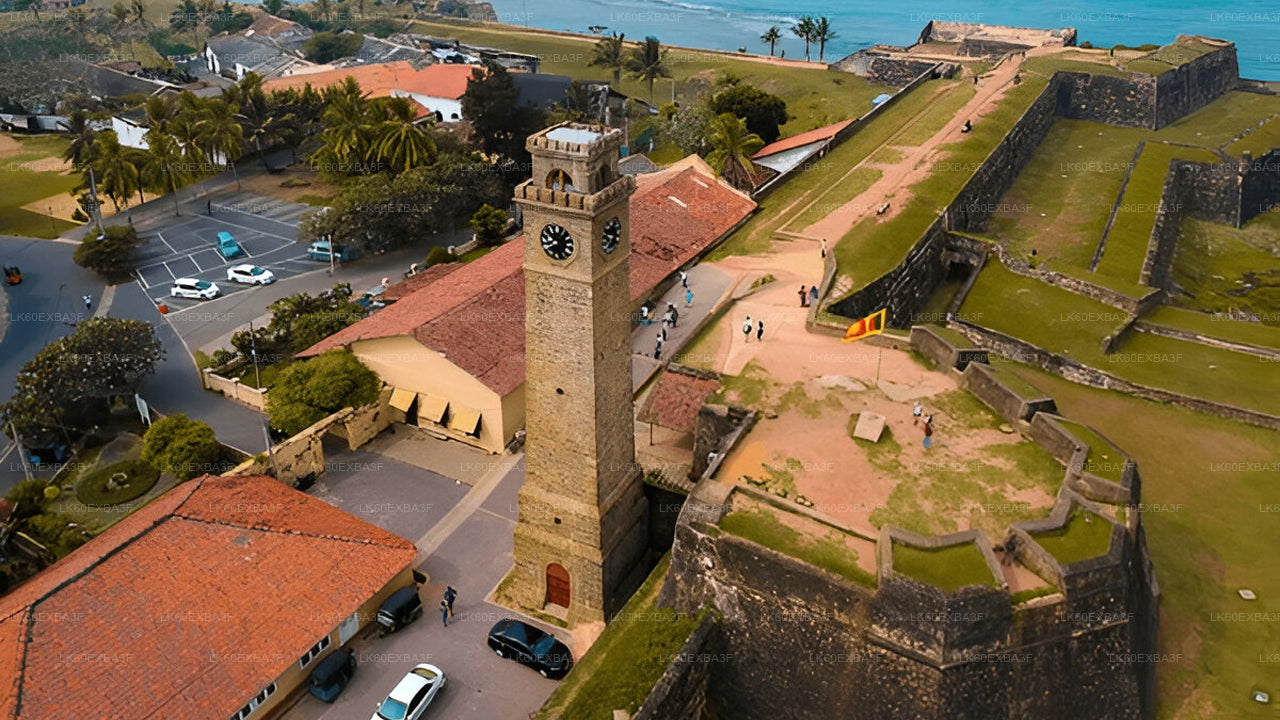 Historic clock tower within a fortification complex near a body of water.