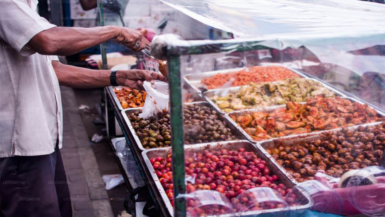Vendor selling various types of street food at a market in Galle Fort, Sri Lanka.